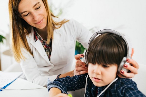 Аудиолог, изучающий слух у ребенка