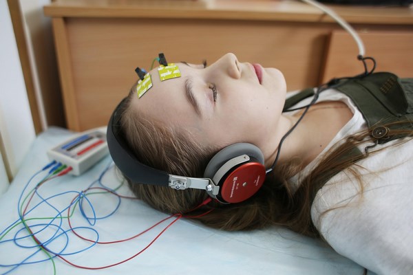 На фото изображена девочка во время исследования слуха